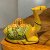 Close-up view of the detailed hand-painted landscape and patterns on the blanket of a papier-mache camel statue.