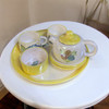 Close-up of the delicate hand-painted floral rose pattern on the ceramic teapot