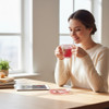 Three-quarter exhibition view of a premium hand-painted glass coffee cup resting on a matching oblong saucer, decorated with an intricate red and white lace pattern.