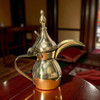 A 5-inch handmade polished brass Arabic Dallah coffee pot with a traditional bird-beak spout and curved handle.