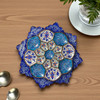 A professional product display shot of the 16 cm royal blue and turquoise Minakari copper plate positioned against an elegant living room background.