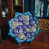 A professional product display shot of the 16 cm cobalt blue floral Minakari copper plate positioned against a dark teal wall background.