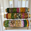 A large display of assorted natural stone bead bracelets in various colors including green, yellow, pink, and purple.