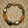 A handcrafted stretch bracelet featuring polished rectangular stone beads in earthy green, slate, and orange tones.
