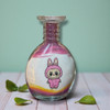 A 13 cm glass bottle filled with layered purple, white, and orange sand, featuring a cute pink bunny character in the center.