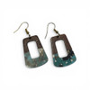 Close-up view of the earrings showing the natural wood grain joined with teal resin containing gold and black marbled accents.
