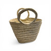 A perspective view of the deep-bellied palm leaf basket, highlighting its large capacity for laundry or decorative storage.