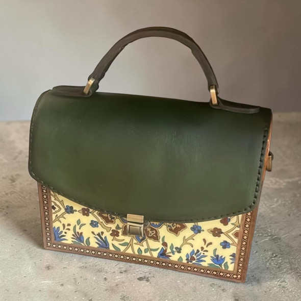 A professional product presentation of the "Mia" 21x16x7.5 cm handcrafted green leather and wooden gift handbag against a neutral background.