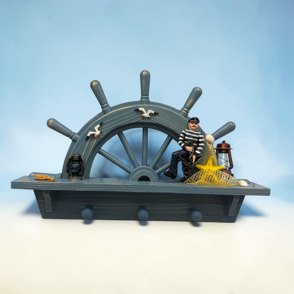 A detailed close-up highlighting the seated sailor figurine in a striped shirt, yellow starfish in a fishing net, vintage lanterns, and distressed blue wood finish