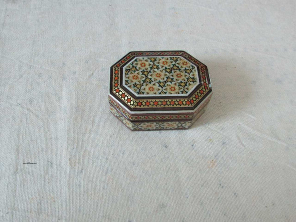 Close-up of the microscopic brass, bone, and wood triangle inlaying technique on the 7 cm decorative Persian box.