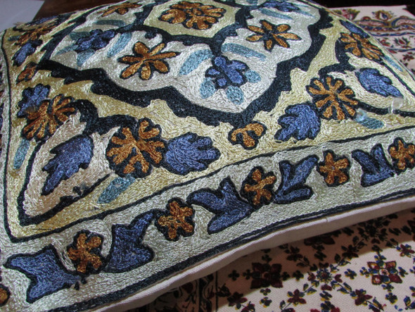 Close-up of the intricate hand-sewn stitching and textured thread work on the vintage Kashmiri pillow cover.