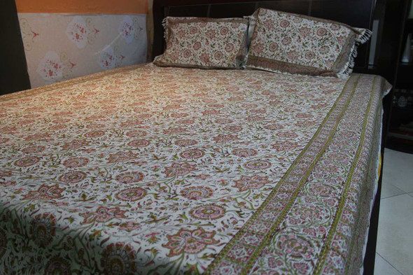 A boho-chic bedroom featuring a Persian tapestry bed sheet used as a decorative coverlet