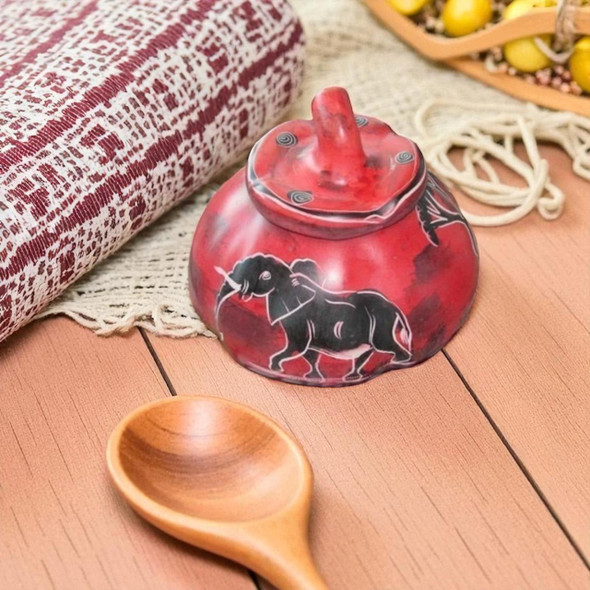 A premium 10x8 cm hand-carved red soapstone sugar bowl titled "The Crimson Gourd" featuring pumpkin-shaped ribs and etched patterns.