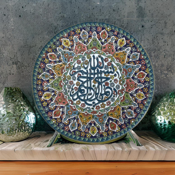 A premium 25 cm handmade clay plate featuring intricate Islamic calligraphy surrounded by a vibrant, multi-colored floral mosaic for wall decor.