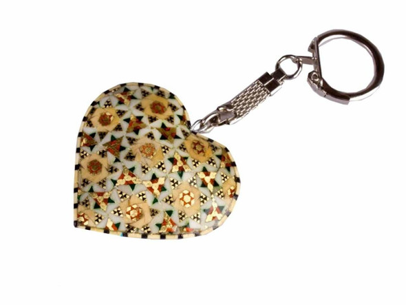 A close-up of a heart-shaped wooden keychain featuring intricate Khatamkari geometric inlay patterns in gold, brown, and cream.