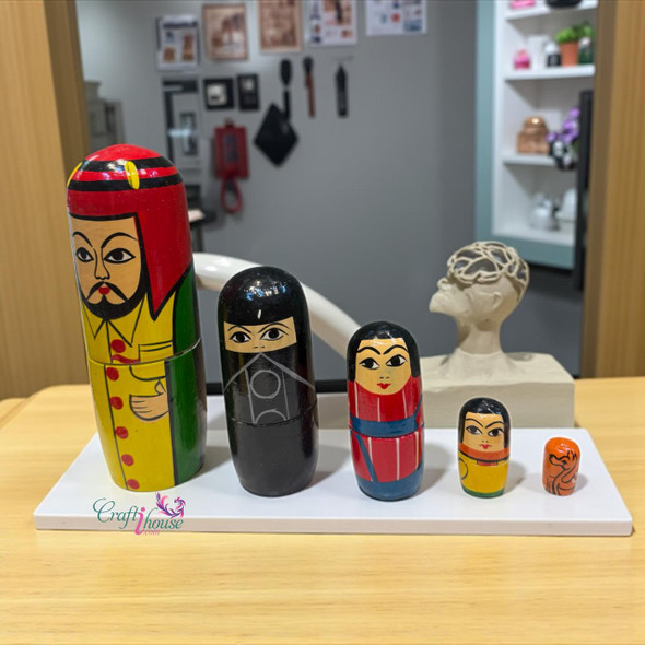 Detailed view of the second-largest doll representing an Arabian mother in a traditional black abaya with gold accents.