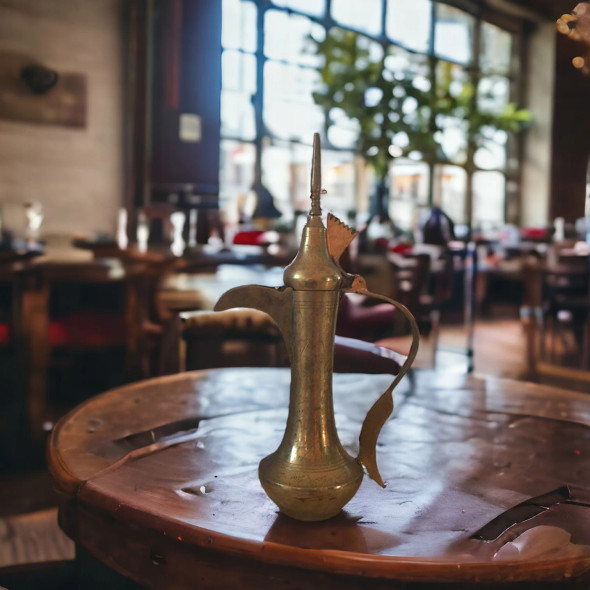 Close-up of the high-pointed finial and the hand-engraved lid of the 45 cm decorative Arabic coffee pot.