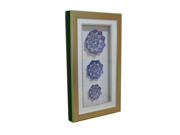 Close-up of the three delicate, hand-painted Meenakari plates arranged vertically within a refined wooden frame.