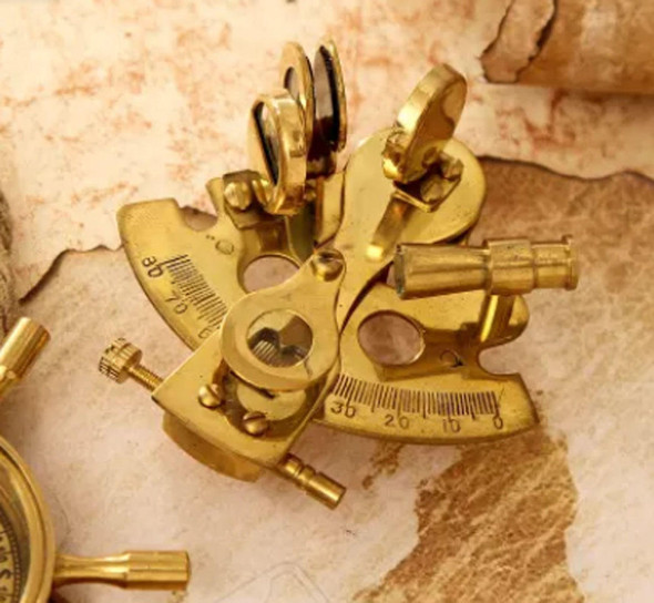 Close-up of the intricate brass detailing on a vintage maritime sextant, showcasing its craftsmanship and historical aesthetic.