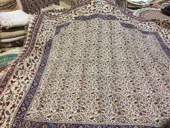 A traditional wooden printing stamp resting on a Qalamkar fabric, illustrating the handmade process