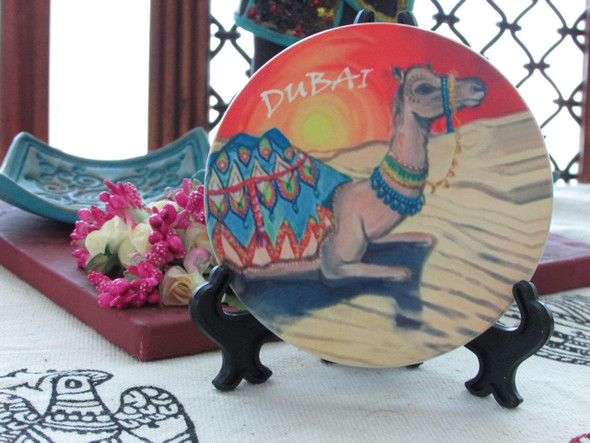 A premium ceramic tea coaster featuring a high-definition printed pattern of a camel caravan in the desert.