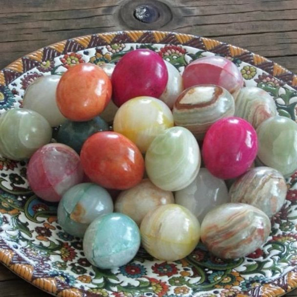 A high-polished, hand-carved onyx marble stone egg showing natural green and brown banding.
