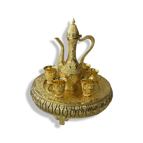 A detailed close-up highlighting the intricate metallic engravings, polished golden finish, and traditional craftsmanship of the coffee set pieces