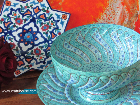 نمای نزدیک از ظرافت نقوش اسلیمی روی بشقاب میناکاری که کیفیت لعاب و درخشش مس را نشان می‌دهد