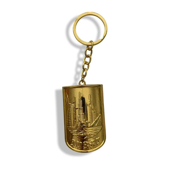Close-up of the intricate gold embossing on the Dubai keychain, highlighting the Burj Khalifa silhouette.