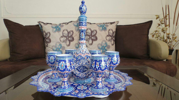 A complete 7-piece Minakari copper set featuring a large pitcher and six matching goblets with intricate blue enamel floral art.