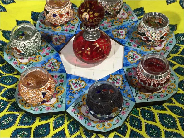 Detailed view of the intricate glass mosaic tea light holders displayed on a handcrafted wooden tray