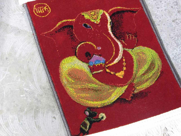 Close-up of the sharp, machine-woven details and vibrant orange colors of the Ganesha wall hanging.
