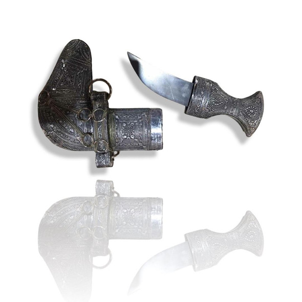 Detailed macro shot of the silver hilt and scabbard on a Dubai Khanjar, showcasing intricate Arabian craftsmanship.