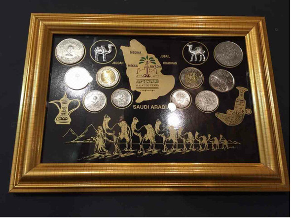 An elegantly designed display frame containing a curated set of Saudi Arabian souvenir coins.