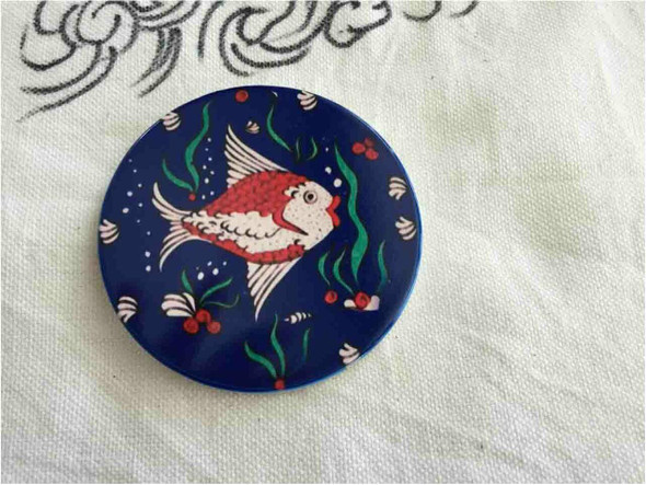 The ceramic coaster showcasing its sharp, high-quality printed fish design, perfect for collectors of unique table accessories.
