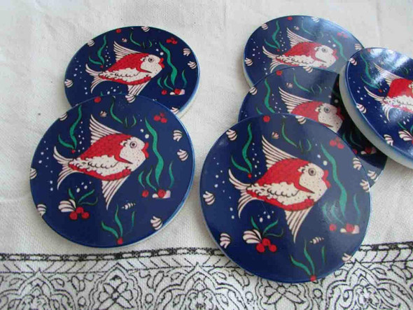 Close-up of the printed ceramic coaster showing detailed fish and seaweed graphic motifs, ideal for adding a coastal touch to your home.