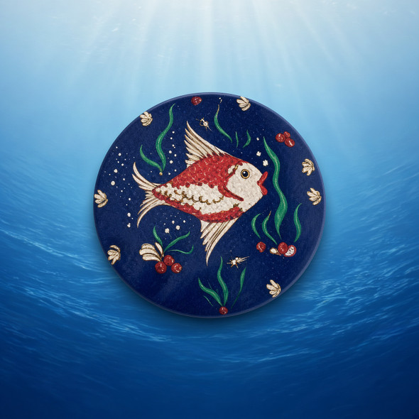 A professionally presented 9 cm round printed ceramic coaster featuring a red and white ocean fish motif on a deep navy blue aquatic background.