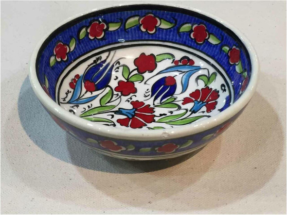 The red tulip Iznik ceramic bowl shown as a sophisticated serving dish for dates and nuts in a modern luxury home setting.