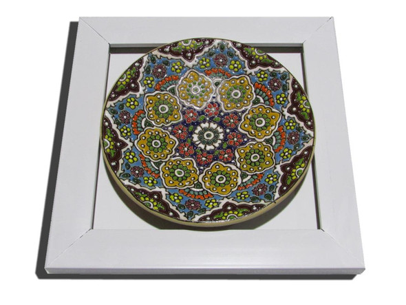 A 15 cm assorted pattern embossed painted clay plate mounted inside a clean white square wall frame.