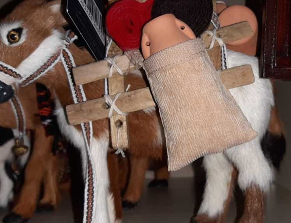 A professional product display shot of the 18 cm fur donkey sculpture against a neutral and decorative background.