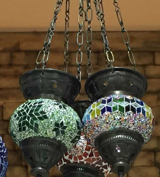 Close-up view of the artisan mosaic candle holder globes showcasing vibrant stained glass pieces and antique metal hardware.