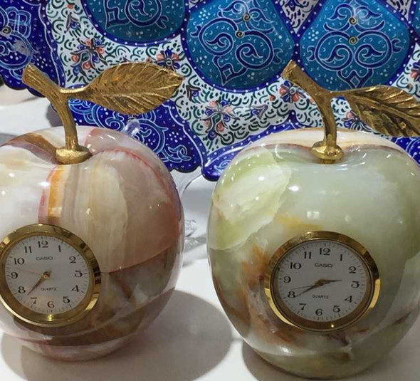 A professional lifestyle presentation shot of the stone apple clock showcasing its unique mineral patterns as a luxury executive desk accessory.