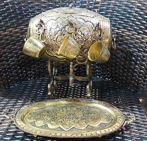 A professional product presentation of the exclusive handmade brass barrel drinkware set from a premier UAE shop.