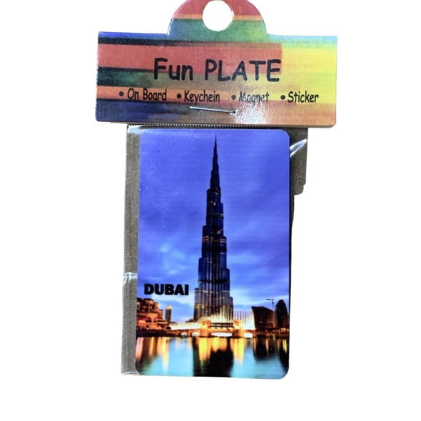 A professional product presentation of the Dubai landmark aluminium fridge magnet from a premier UAE gift shop.