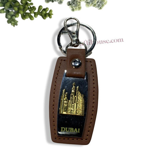Close-up of the premium stitching and debossed Dubai text on a tan PU leather key holder.