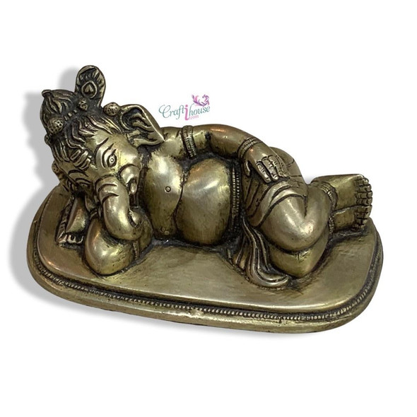 A beautifully polished brass sleeping Lord Ganesha, an ideal centerpiece for meditation spaces or shelves.