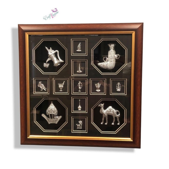 A premium 13-icon UAE heritage souvenir frame featuring silver-toned symbols like the camel, dhow, and Burj Khalifa in a wooden frame.