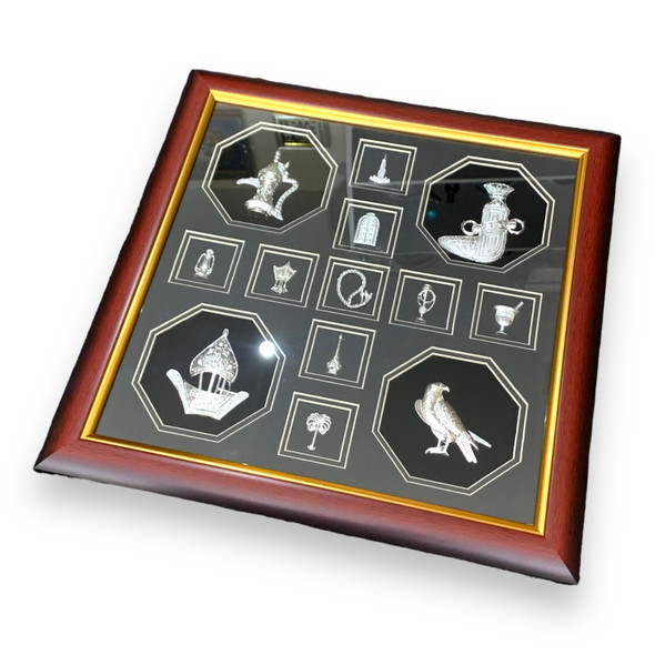 Close-up of the detailed silver-tone reliefs of the Burj Al Arab, falcon, and traditional coffee pot inside the souvenir frame.