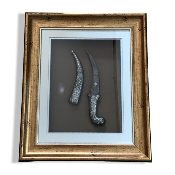 Full setting presentation of the premium framed Middle Eastern heritage dagger styled on an upscale corporate majlis wall serving as an elite milestone token or VIP hospitality giveaway decoration in Dubai.