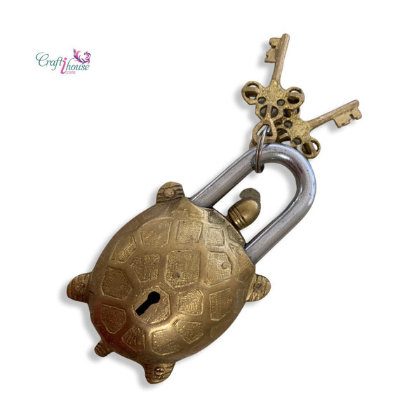 A handcrafted solid brass turtle lock with a textured shell and two brass skeleton keys.